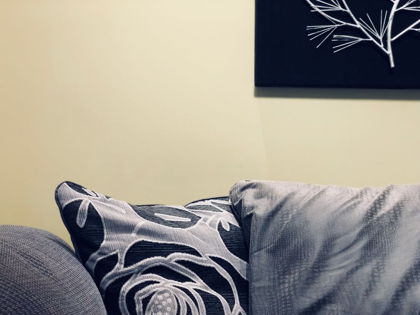 Stylish modern interior features a cozy sofa with decorative throw pillows and wall art.